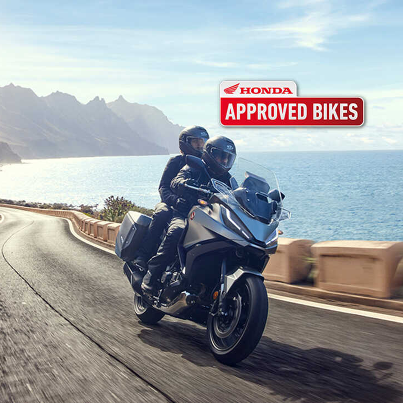 NT1100 riding along the coastline with a passenger